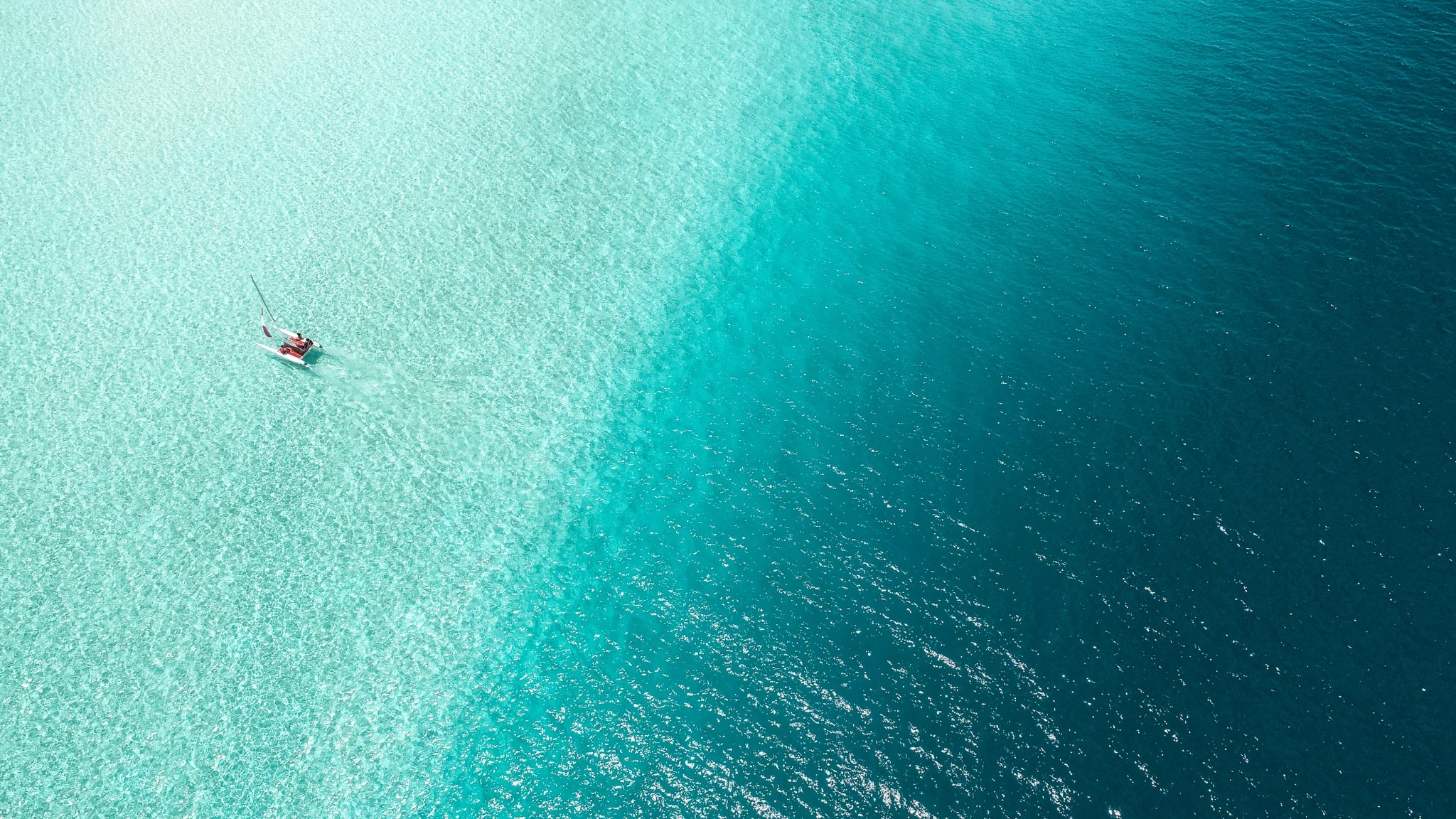 Boat crossing shallow tropical ocean water